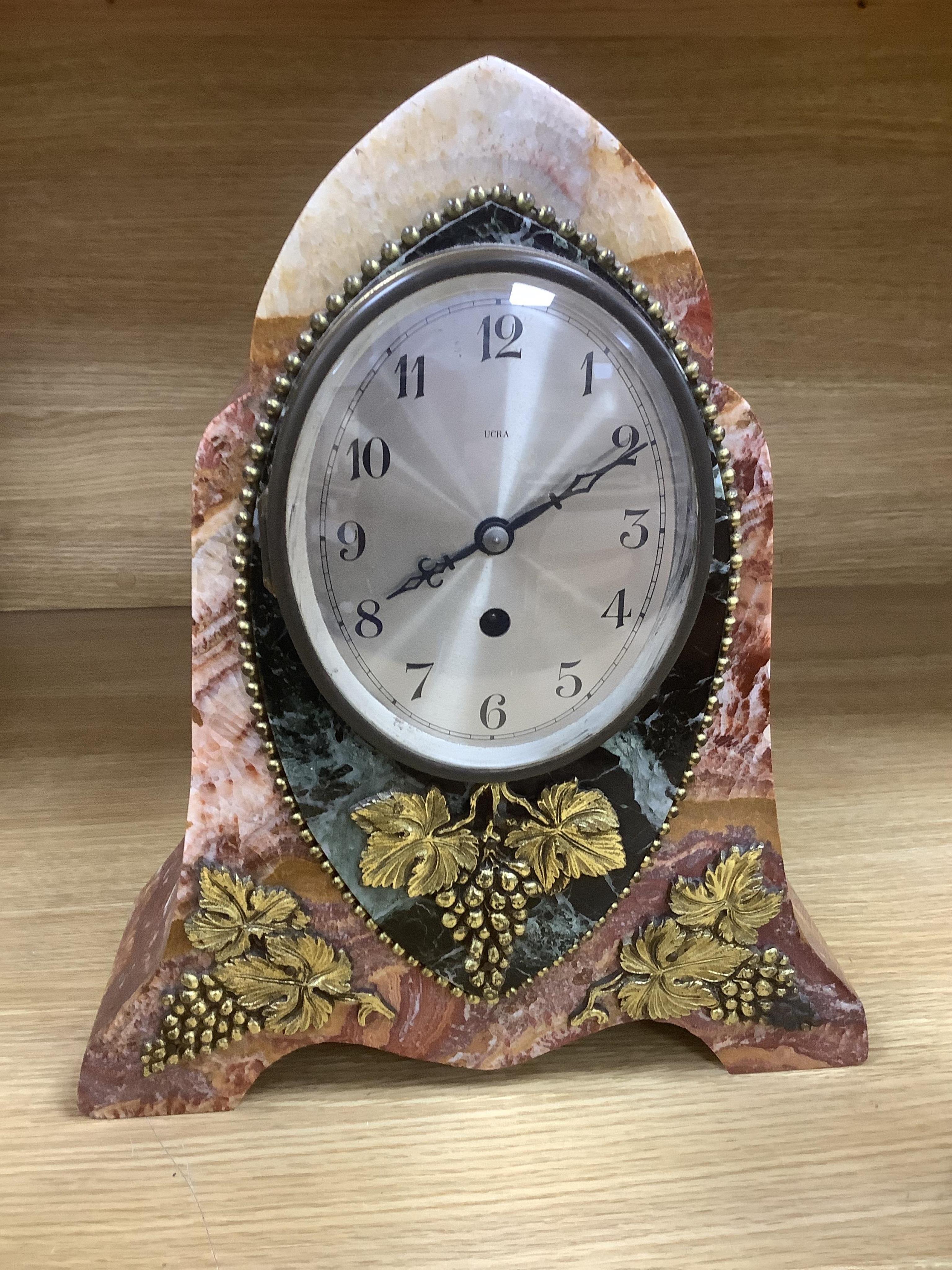 An early 20th century French rouge and black marble clock garniture with ornamental grape motif mounts to the clock and with a key. Clock 34.5 cm high